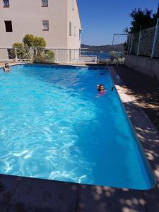 a child swimming in a large blue swimming pool at les marines de Tamaris in La Seyne-sur-Mer +13 photos