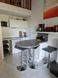 uma cozinha com uma mesa e dois bancos de bar em les marines de Tamaris em La Seyne-sur-Mer