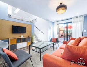 a living room with a couch and a table at Marvel House - Disneyland 5min, Private Parking, Terrace in Magny-le-Hongre