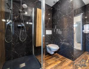 a bathroom with a toilet and a glass shower at Marvel House - Disneyland 5min, Private Parking, Terrace in Magny-le-Hongre
