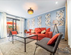 a living room with a red couch and a glass table at Marvel House - Disneyland 5min, Private Parking, Terrace in Magny-le-Hongre