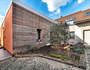 a house with a wooden retaining wall at Marvel House - Disneyland 5min, Private Parking, Terrace in Magny-le-Hongre