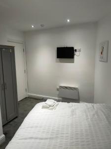 a bedroom with a bed with a tv on the wall at Beautiful Double Bedroom in Liverpool