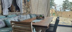 un tavolo in legno in un soggiorno con divano di Elouthia Residence with Sea View and Hot Tub a Tsoutsouros