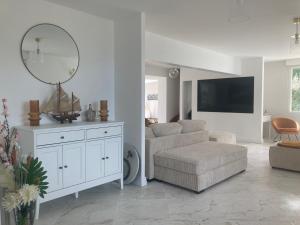 Sala de estar blanca con silla y espejo en La Villa de Puys - Dieppe, en Dieppe