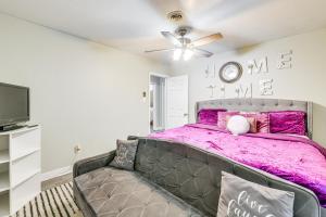 1 Schlafzimmer mit einem lila Bett und einem TV in der Unterkunft Colorful Hopewell Home about 5 Mi to the James River! in Hopewell
