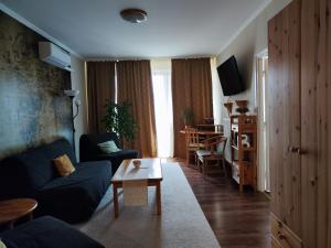 sala de estar con sofá y mesa en St. Benedek Apartmanlakás, en Mezőkövesd