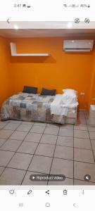 un letto in una camera con parete arancione di Relais Maria Luisa Locazione turistica di Simona Capaccio a Fiumicino