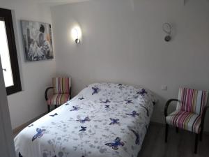 Cases-de-PèneにあるCharmant appartement T2 neuf ,calme tout confort.のベッドルーム1室(ベッド1台、椅子2脚付)