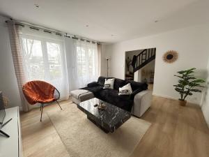 a living room with a couch and a table at Ker Heol - Maison au Nord Finistère in Lesneven +4 photos