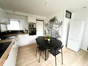 a kitchen with a black table and black chairs at Ker Heol - Maison au Nord Finistère in Lesneven +4 photos