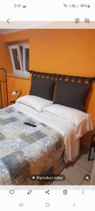 a bedroom with a large bed with an orange wall at Relais Maria Luisa Locazione turistica di Simona Capaccio in Fiumicino