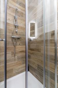 a shower in a bathroom with wooden walls at Hotel No.9 in Derry Londonderry