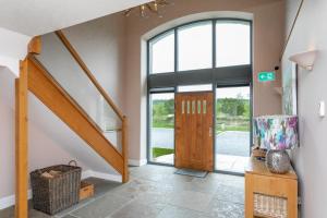 a hallway with a wooden door and a staircase at Brockram & Keld Barns in Kirkby Stephen