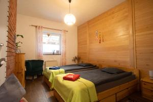 a bedroom with two beds and a chair and a window at CHILL Village in Nowinka
