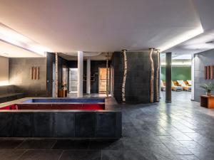 アンテルセルヴァ・ディ・メッツォにあるFalkensteiner Hotel Antholz - Adults onlyの建物の中央にプールがあるロビー