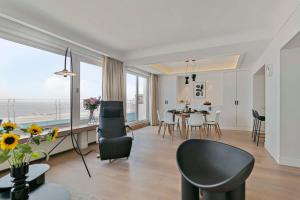 een woonkamer en eetkamer met een tafel en stoelen bij Huswell - Panoramic seaview apartment in 't Zoute in Knokke-Heist