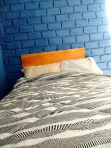 een blauwe slaapkamer met een bed met een blauwe muur bij Bugambilia house in Ica