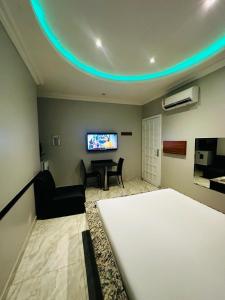 Habitación con cama y sala de estar con TV. en Pousada Ponta Negra en Manaus