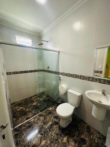 y baño con aseo, lavabo y ducha. en Pousada Ponta Negra en Manaus
