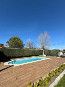 a swimming pool in a yard with a wooden deck at Casa Rascafría in Rascafría