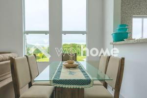 uma sala de jantar com uma mesa de vidro e cadeiras em Casa com piscina em condomínio em Itupeva em Itupeva