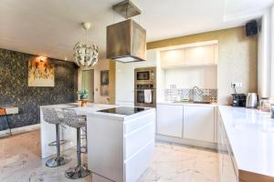 a kitchen with white cabinets and a large island at Casa Vega — Luxury suite, banks of the River Orne in Caen