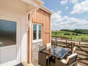 a patio with a table and chairs next to a building at Emminster in Weymouth