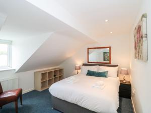 a bedroom with a large white bed and a mirror at Emminster in Weymouth