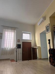 een lege kamer met een gitaar en een raam bij Sirtori 8A in Quartu SantʼElena