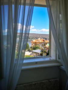 a window with a vase of flowers on a window sill at APARTMENT VOLOSKO - 50m to the sea in Opatija