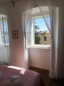 a bedroom with a bed and a large window at APARTMENT VOLOSKO - 50m to the sea in Opatija +23 photos