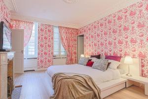 a bedroom with a bed with pink floral wallpaper at Duplex d'exception face Hippodrome avec Jardin in Chantilly