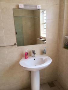 ein Bad mit einem Waschbecken und einem Spiegel in der Unterkunft CASBAH HOMES in Nairobi