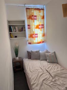 ein kleines Schlafzimmer mit einem Bett und einem Fenster in der Unterkunft Centre Juan Les Pins 3P Les Iles Plages 50 mètres in Antibes