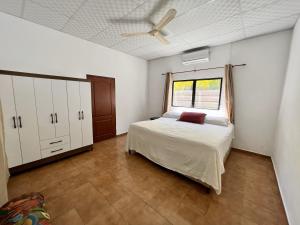 1 dormitorio con 1 cama y ventilador de techo en Beautiful beach house in Los Cobanos El Salvador, en Los Cóbanos
