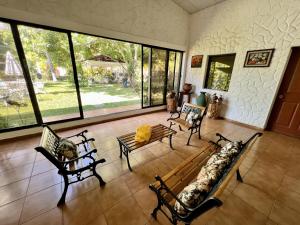 a large living room with benches and windows at Beautiful beach house in Los Cobanos El Salvador in Los Cóbanos