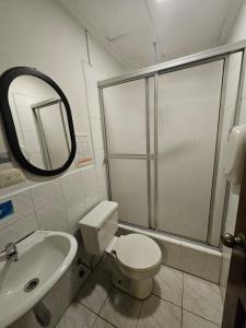 een badkamer met een toilet, een wastafel en een spiegel bij alborada cuenca hospedaje in Cuenca