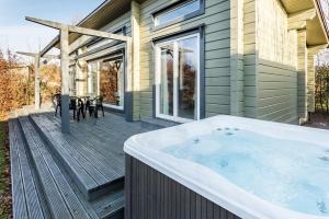 bañera de hidromasaje en la cubierta de una casa en Roydon Marina - Lodge 3 - Hot Tub en Roydon