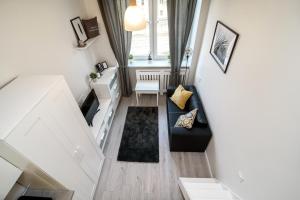 una pequeña sala de estar con sofá negro y ventana en Cozy Loft / Near Gates of Dawn / Free Netflix, en Vilna 10 fotos más