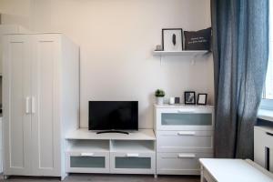 a living room with a tv and a white cabinet at Cozy Loft / Near Gates of Dawn / Free Netflix in Vilnius