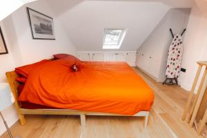 um quarto com uma cama com um cobertor laranja em Moose Cottage em Newton Ferrers