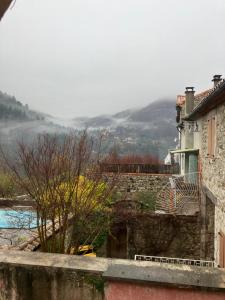 a view of a house with a mountain in the background at Le Boustrophédon in Antraigues