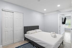 a white bedroom with a bed and a tv at Upgraded Ground Floor Residence on Buttonwood Ln w Bikes in Sanibel