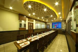 a long dining room with a long table with chairs at Royal Stay in Bengaluru