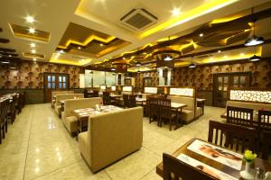 a dining room with tables and chairs in a restaurant at Royal Stay in Bengaluru