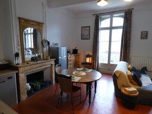 een woonkamer met een tafel en een bank bij "Le Bouquet de Pézenas" Wifi-Garage privé optionnel Centre historique-Plages à 21km ! in Pézenas