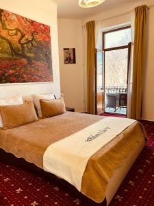 um quarto com uma cama grande e uma pintura grande na parede em Hotel Zava Boutique Central em Bucareste
