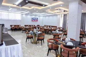 a restaurant with tables and chairs in a room at Gloria Inn Hotel - Ndola in Ndola