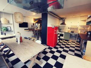 uma cozinha com um frigorífico vermelho e um piso em xadrez em Backpackers Luzern em Lucerna